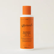 Orange bottle of Glymed+ Blemish Control No. 5 on a beige background